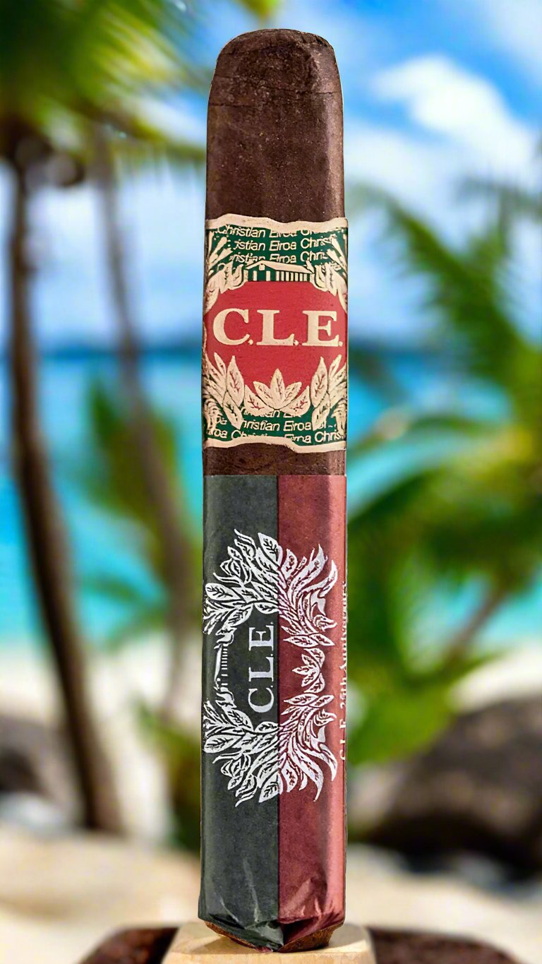 A single C.L.E 25th Anniversary Robusto cigar against a tropical background