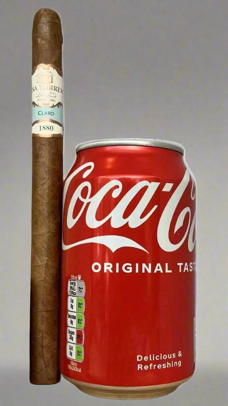 A single Casa Turrent 1880 Claro Lancero cigar next to a can of coca cola to show scale, the cigar is about 50% longer than the can.