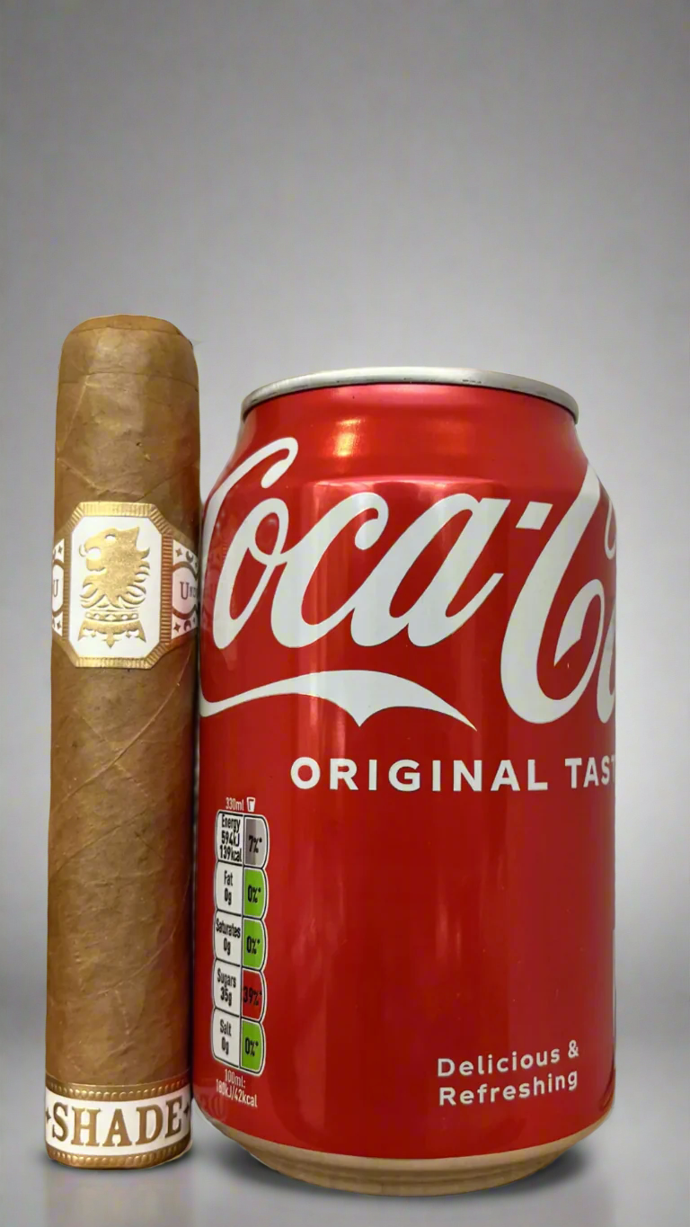 A single Drew Estate Undercrown Shade Robusto next to a can of coca cola to show scale, the cigar is slightly longer than the can.