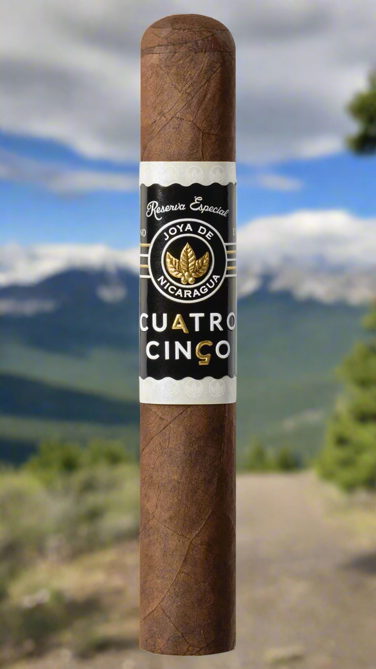 A single Joya De Nicaragua Cuatro Cinco Petit Corona cigar on a mountain path in Nicaragua.