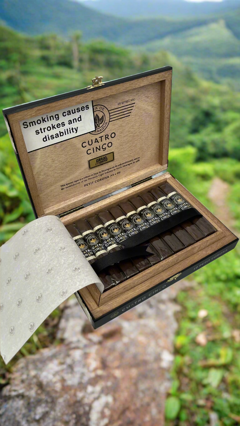 A box of Joya De Nicaragua Cuatro Cinco Petit Corona cigars on a mountain path in Nicaragua.