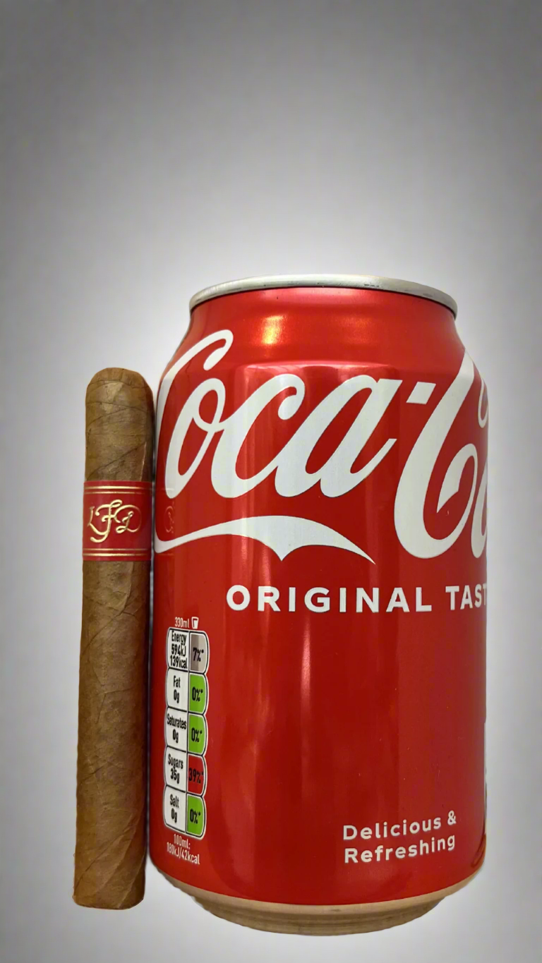 A single La Flor Dominicana El Carajon next to a can of coca cola to show scale, the cigar is a few centimetres shorter than the can.