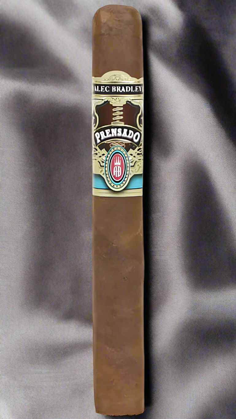 A single Alec Bradley Prensado Corona Gorda cigar places atop grey silk