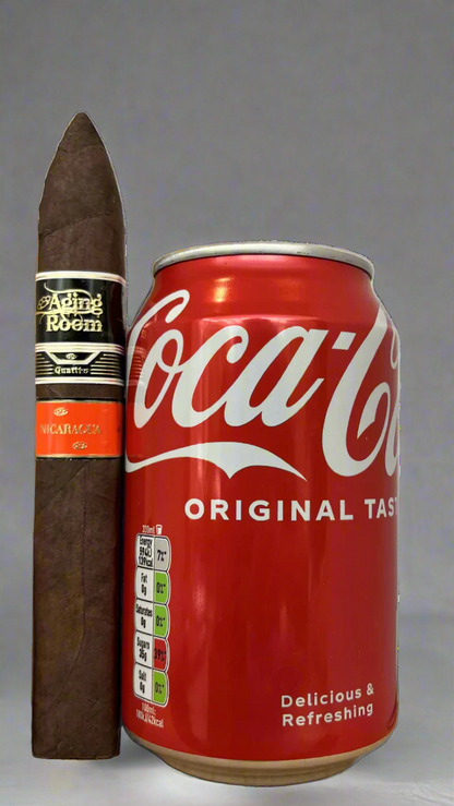 A single Aging Room Nicaragua Quattro Maestro against a can of coca cola to show the size