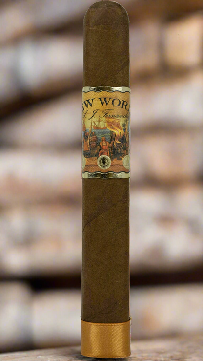 A single A.J. Fernandez New World Dorado cigar against a brick background