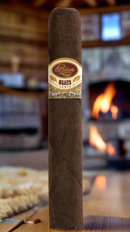 A single Padron No. 45 Family Reserve Maduro cigar in front of a fire in a cozy mountain cabin.