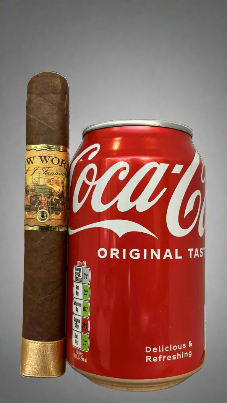 A single A.J. Fernandez New World Dorado cigar next to a can of cola.